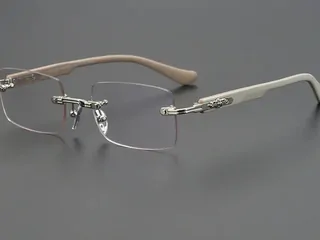 Occhiali senza montatura con aste chiare su fondo grigio