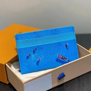 Porta carte azzurro con un disegno di piscina, appoggiato in una scatola arancione